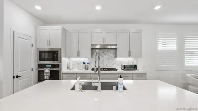 a kitchen with kitchen island a stove a sink and a refrigerator