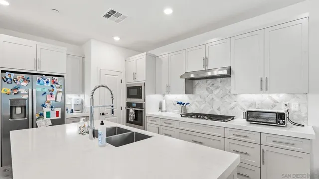a kitchen with stainless steel appliances granite countertop a sink refrigerator and cabinets