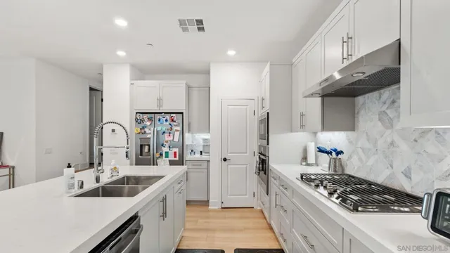 a kitchen with stainless steel appliances granite countertop a sink and a stove