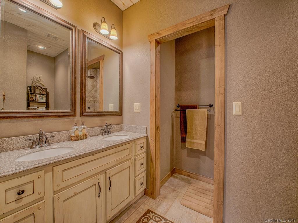 295 Rice Cove Road Canton, NC 28716 - Photo 18 of 24 a bathroom with a granite countertop sink and a mirror