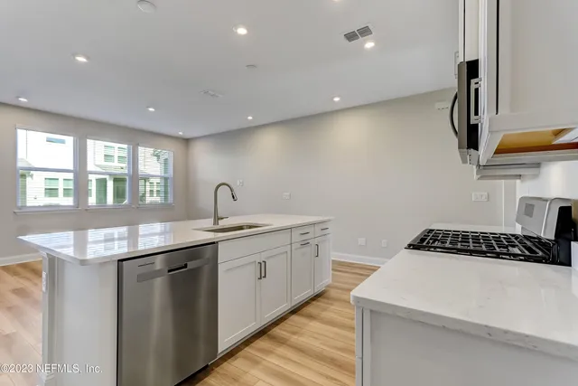 a kitchen that has a sink and a stove in it