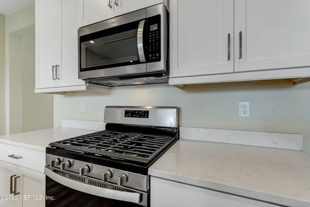a kitchen with microwave cabinets and stove top oven