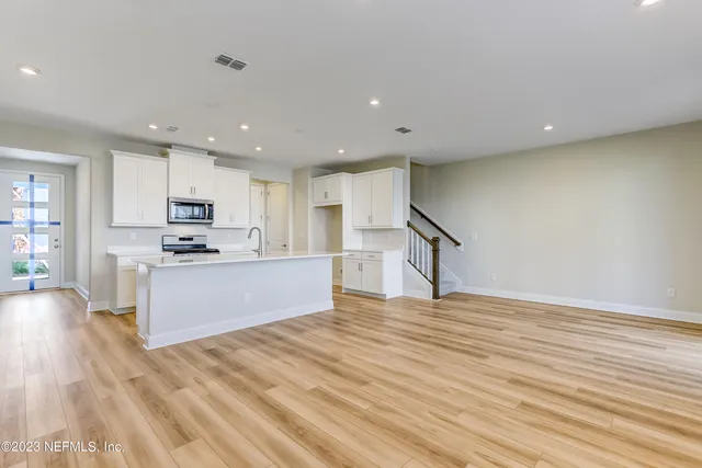 a view of kitchen with microwave and cabinets