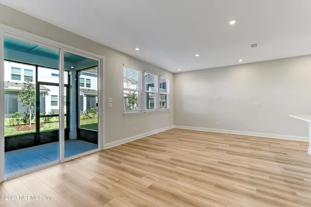 a view of an empty room with glass door and a window