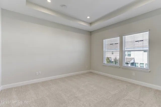 a view of an empty room with a window and a bathroom