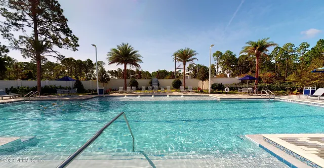 a view of a house with swimming pool and sitting area