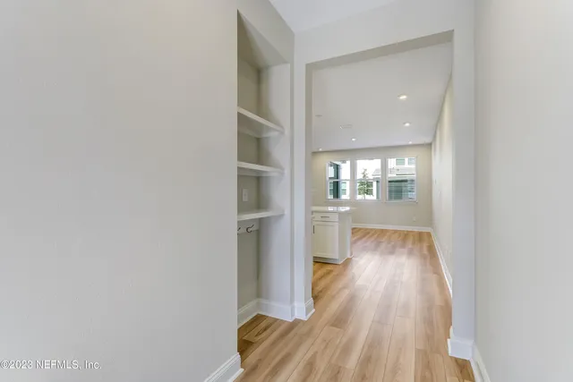 a view of a room with wooden floor kitchen view and a window