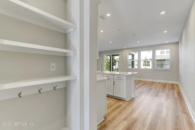 a view of a kitchen with wooden floor and electronic appliances