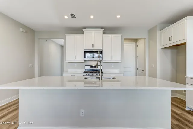 a kitchen with kitchen island a stove a sink and a refrigerator
