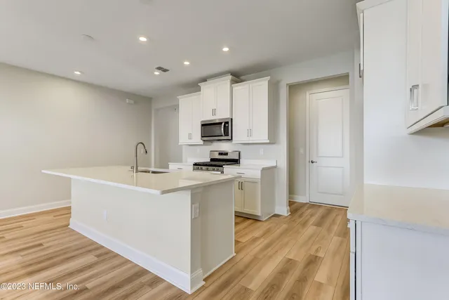 a view of kitchen with sink refrigerator and microwave