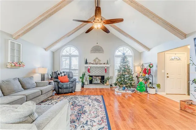 a living room with furniture a fireplace and a chandelier
