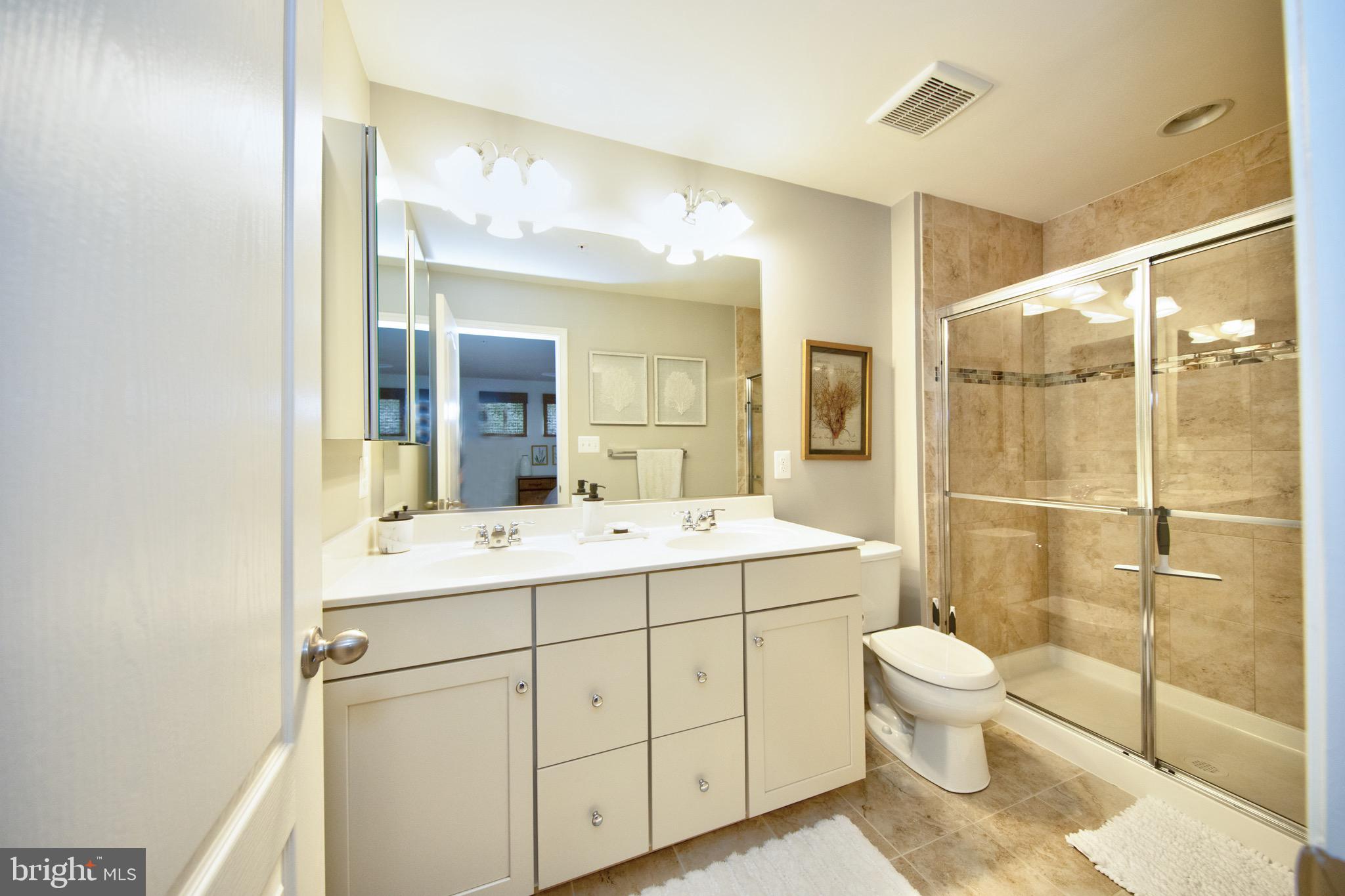 909 Morgan Run Road Baltimore, MD 21220 - Photo 31 of 41 a bathroom with a double vanity sink toilet mirror and shower