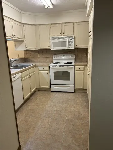 a kitchen with stainless steel appliances a stove a microwave and a sink