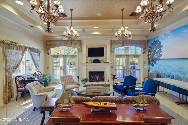 a living room with furniture a chandelier and a fireplace