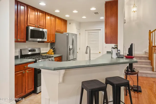 a kitchen with stainless steel appliances granite countertop a sink and a refrigerator