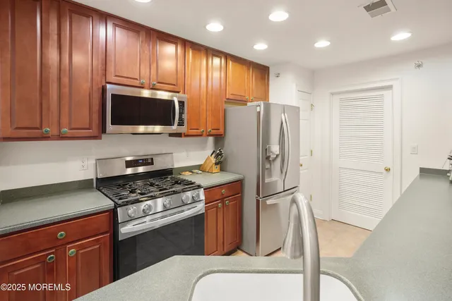 a kitchen with stainless steel appliances granite countertop a refrigerator stove and microwave