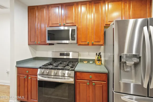 a kitchen with granite countertop stainless steel appliances and wooden cabinets