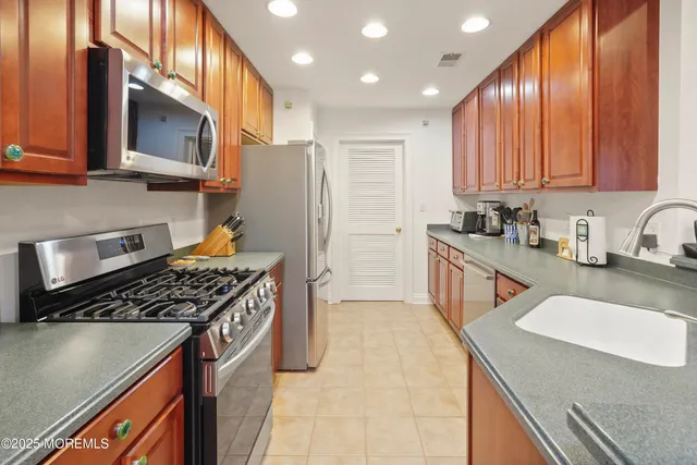 a kitchen with stainless steel appliances granite countertop a sink stove and cabinets