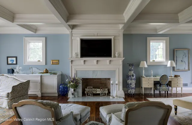 a bedroom with a bed a flat screen tv and a fireplace