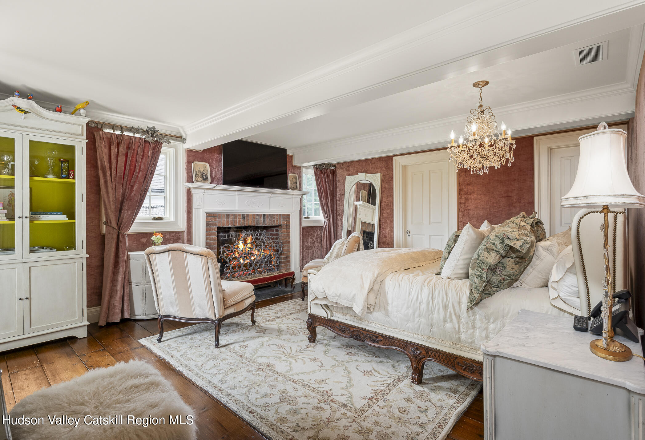 309 Woodstock Road Millbrook, NY 12545 - Photo 25 of 51 a bedroom with a bed a flat screen tv and a fireplace