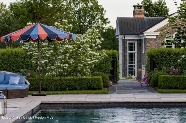 swimming pool view with a seating space and a garden