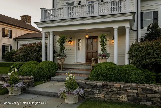 a view of a livingroom with furniture stairs a fireplace and a chandelier