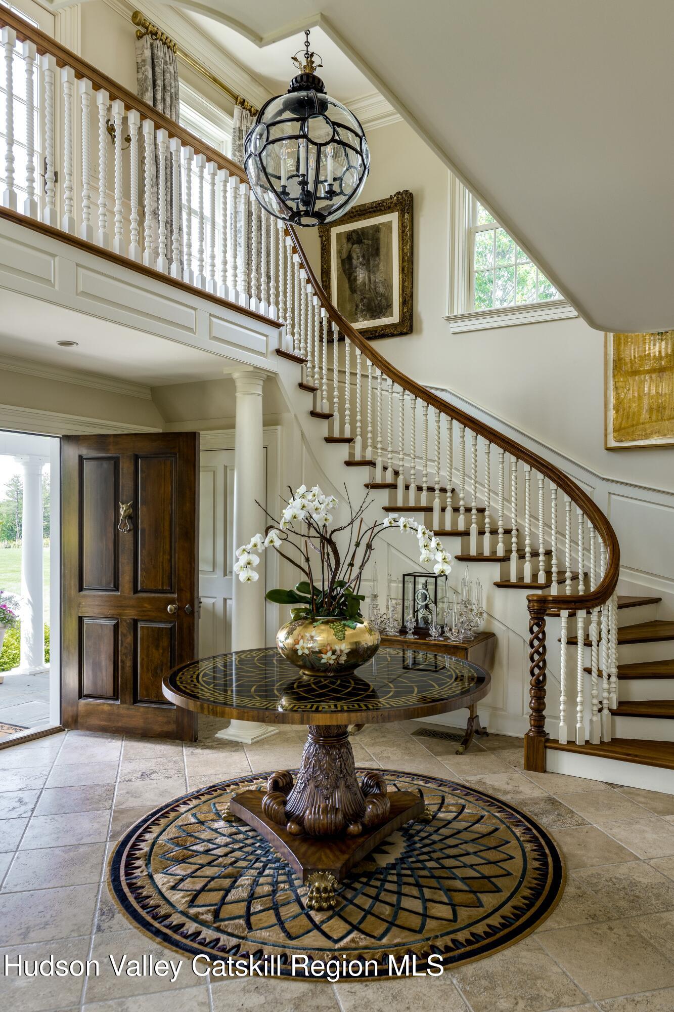 309 Woodstock Road Millbrook, NY 12545 - Photo 5 of 51 a view of a livingroom with furniture stairs a fireplace and a chandelier
