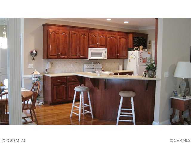 11928 Winterpock Road Chesterfield, VA 23838 - Photo 4 of 12 a kitchen with stainless steel appliances kitchen island granite countertop a sink a table and chairs in it