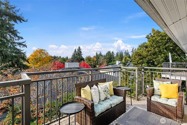 a balcony with wooden floor and outdoor seating