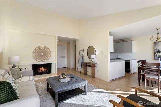 a living room with furniture a fireplace a rug and a window