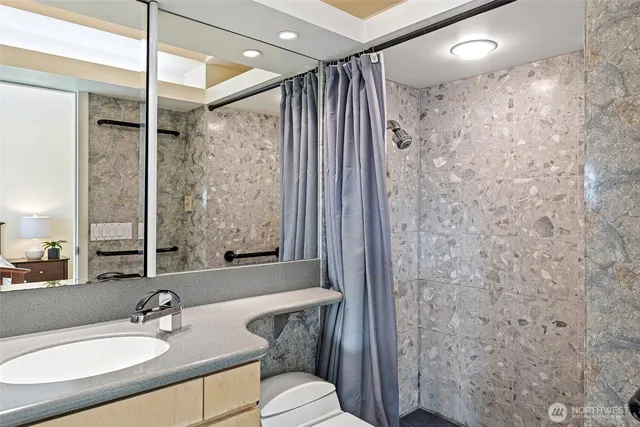 a bathroom with a sink toilet a mirror and shower