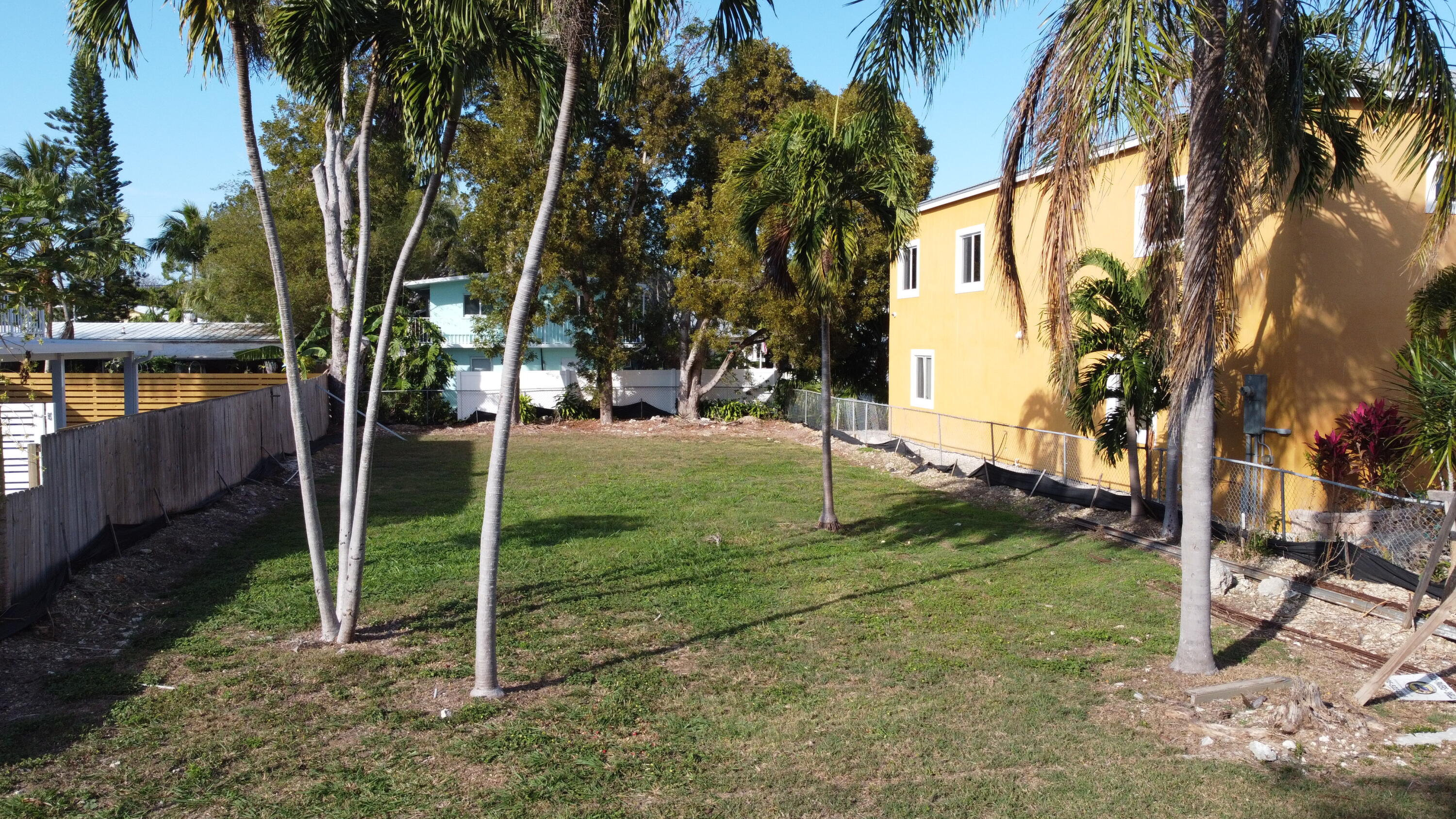62 Southeast Marlin Avenue Key Largo, FL 33037 - Photo 2 of 14 a backyard of a house with table and chairs