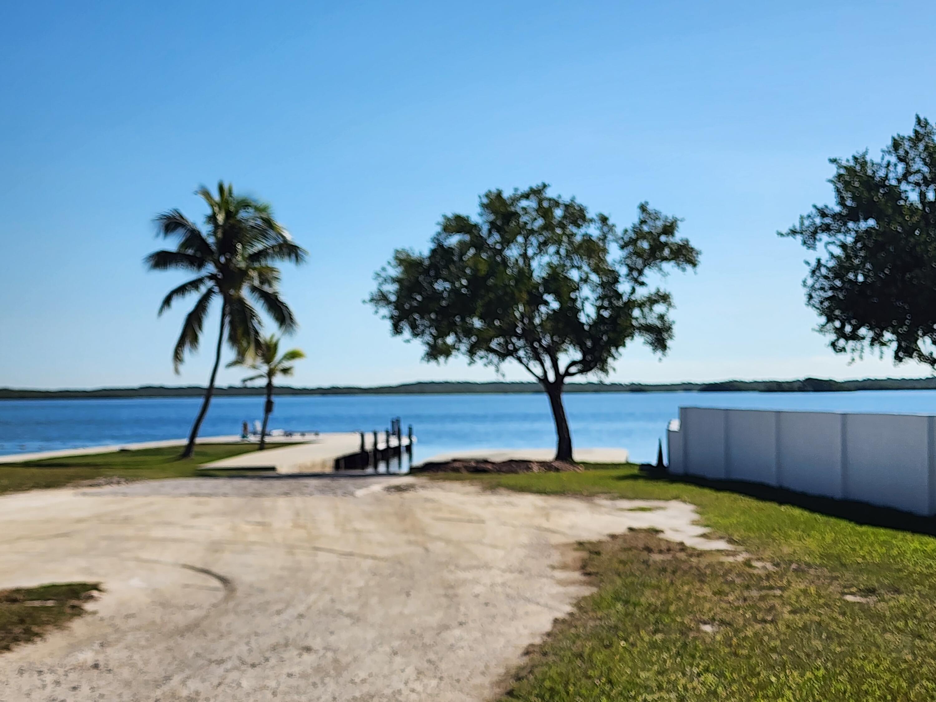 62 Southeast Marlin Avenue Key Largo, FL 33037 - Photo 9 of 14 a view of a swimming pool with a bench and trees
