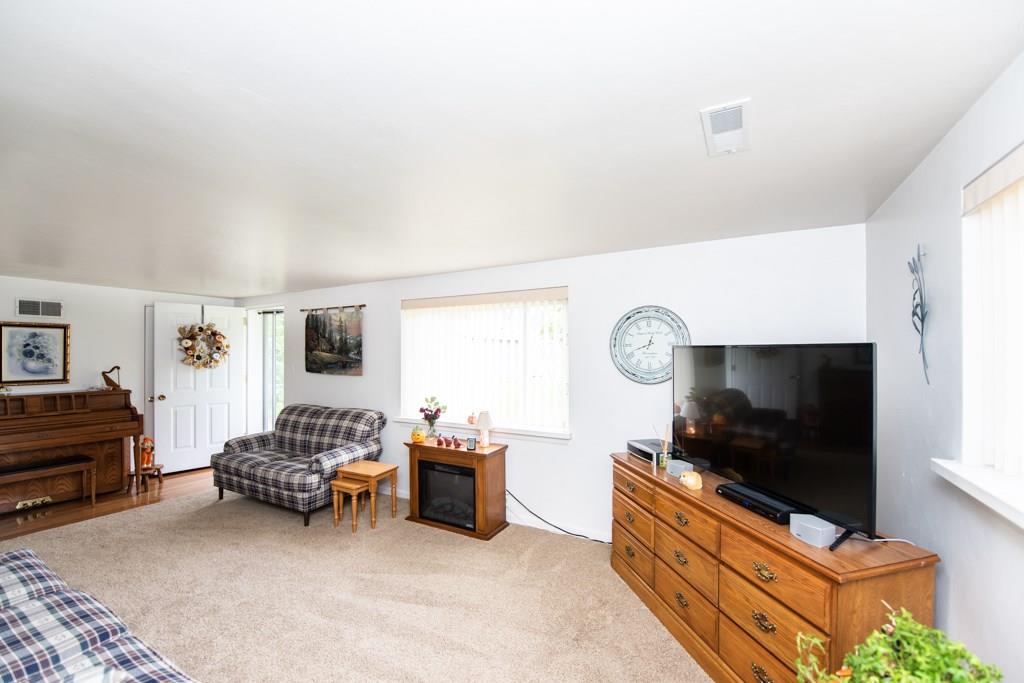 949 Lyn Road Sarver, PA 16055 - Photo 13 of 25 Alternate view of the living room, showing the "official" front entry. Note the hard wood floors do extend beneath the carpet. There is a coat closet behind the open front door. Sorry - the electric fire place is NOT included with the sale of this property.