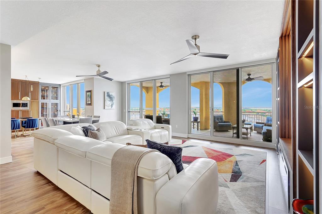 610 Riviera Dunes Way, Unit 602 Palmetto, FL 34221 - Photo 14 of 79 a living room with furniture a chandelier and a large window