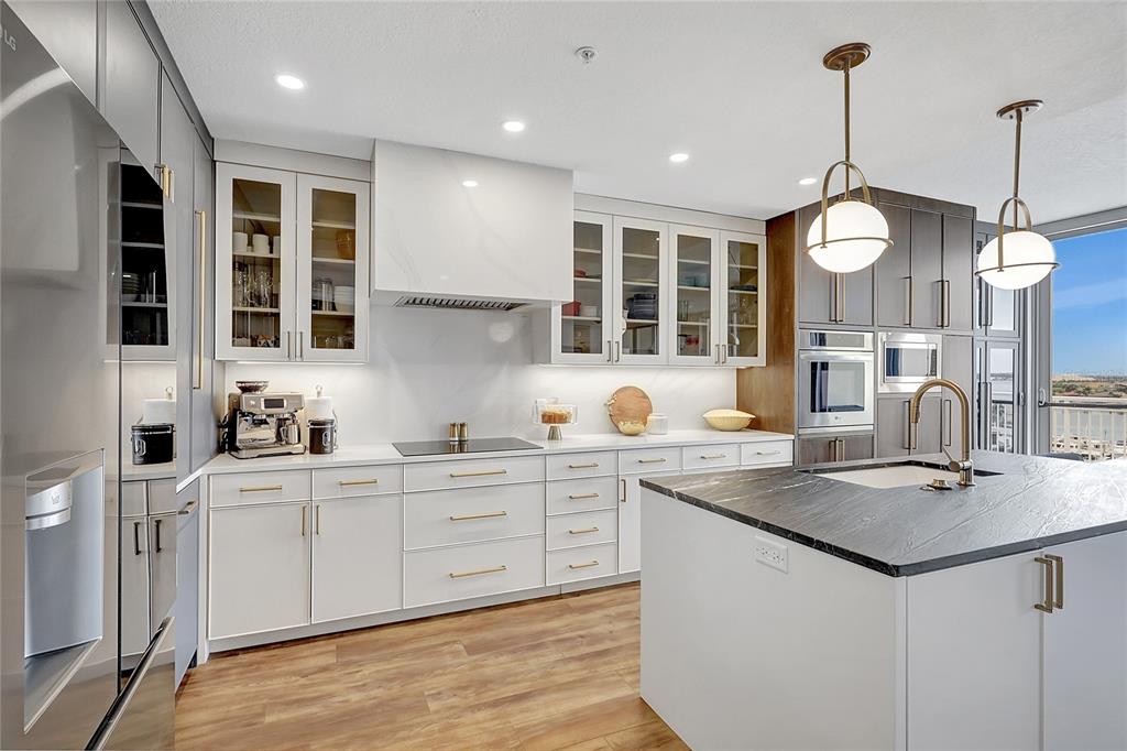 610 Riviera Dunes Way, Unit 602 Palmetto, FL 34221 - Photo 18 of 79 a kitchen with stainless steel appliances granite countertop a sink a stove and a wooden floors