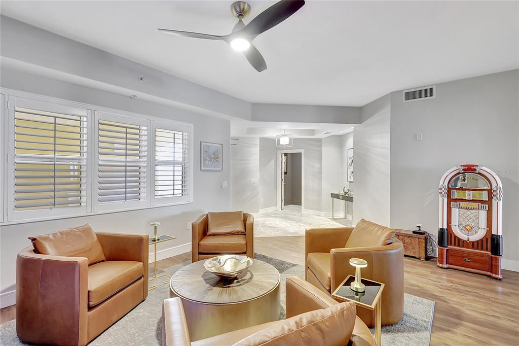 610 Riviera Dunes Way, Unit 602 Palmetto, FL 34221 - Photo 4 of 79 a living room with furniture a table and wooden floor