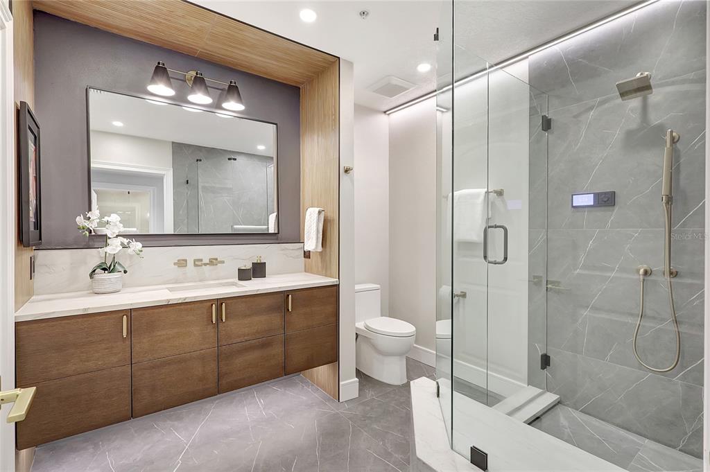 610 Riviera Dunes Way, Unit 602 Palmetto, FL 34221 - Photo 46 of 79 a bathroom with a double vanity sink mirror double shower and a toilet