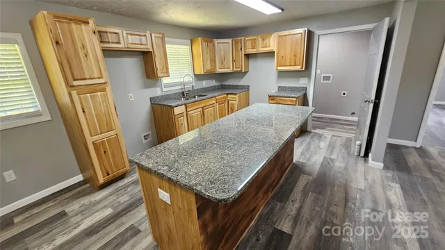 a kitchen with stainless steel appliances granite countertop refrigerator stove and wooden floor