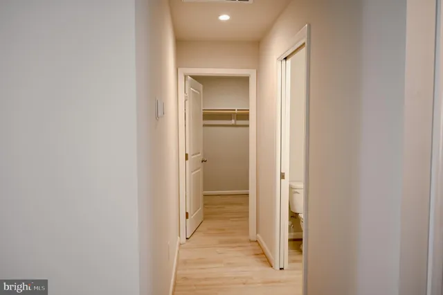 a view of a hallway with wooden shelves
