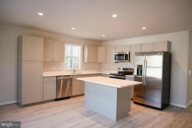 a kitchen with a refrigerator stove a sink and a microwave
