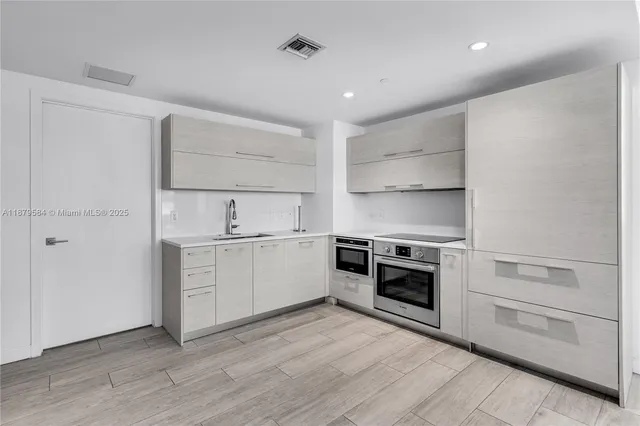 a kitchen with a sink stove and cabinets