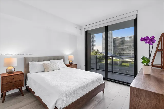 a bedroom with a bed and large window with outer view