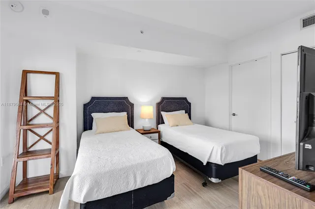 a bedroom with two beds and a window