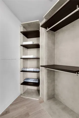 a view of walk in closet with empty racks