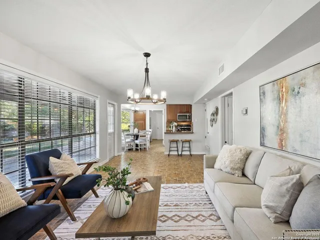 a living room with furniture and a chandelier