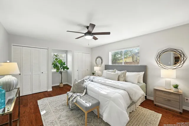 a bedroom with a bed a chandelier and a mirror on the dresser