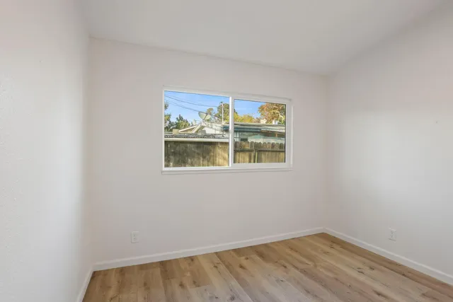 a view of small space with wooden floor and white walls