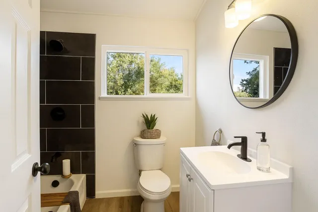 a bathroom with a toilet a sink and a mirror