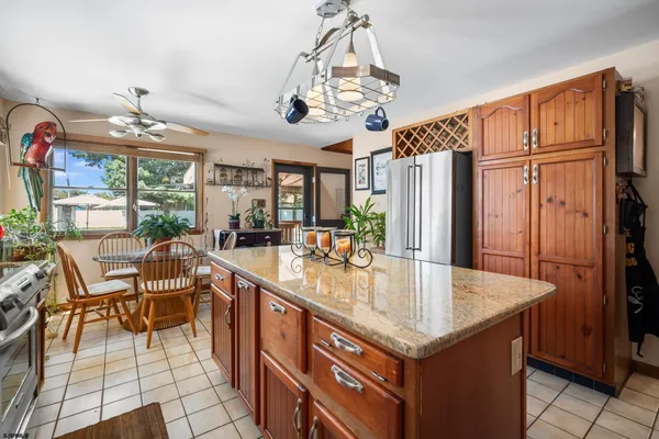 a kitchen with stainless steel appliances granite countertop a table chairs and a refrigerator